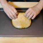 Uomo unge l'impasto pizza integrale sulla teglia